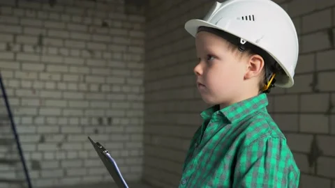A boy with a plan in his hands looks at the work done and checks the documents Stock Footage 238506113