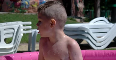 Boy Play and Having Fun in Inflatable Pool on Green Lawn in a Sunny Day Stock Footage 65781547