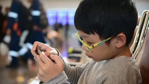 Boy play games on smart phone Stock Footage 69949253