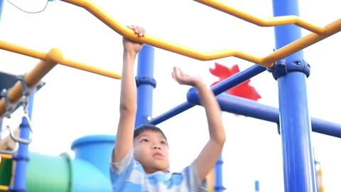 Boy play with hang bar in a summer Stock Footage 85384339