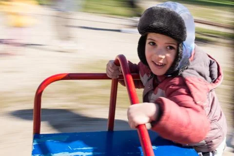 Boy on a playground on carousel. Stock Photos