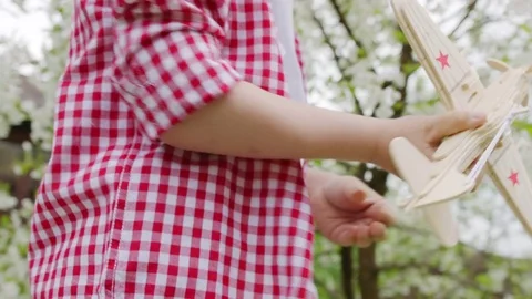 Boy playing airplane in the blooming tree on spring Stock Footage 78557991