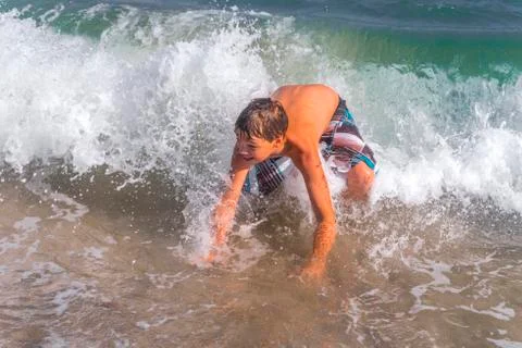 Boy playing and having fun at the beach Stock Photos