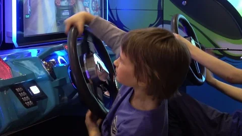 Boy playing auto simulator video arcade game Stock Footage 80873882