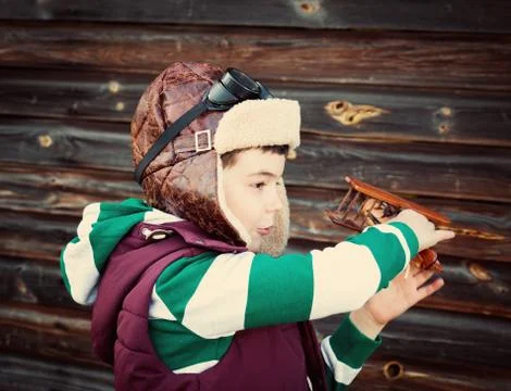 Boy playing in aviator hat with old plane Stock Photos