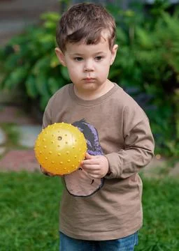 A boy playing with a ball in the backyard Stock Photos