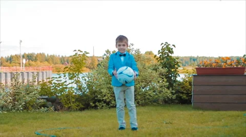 Boy Playing With a Ball in His Yard Stock Footage 68804526