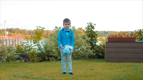 Boy Playing With a Ball in His Yard Stock Footage 68804550