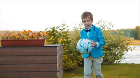 Boy Playing With a Ball in His Yard Stock Footage 68823877