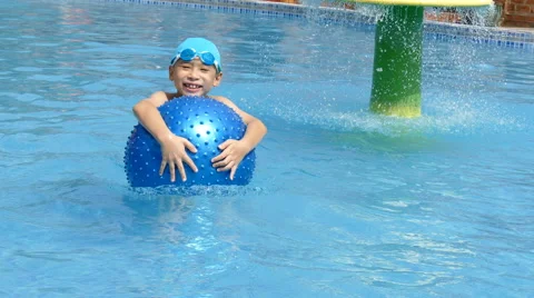 Boy playing with ball in pool Stock Footage 64640240