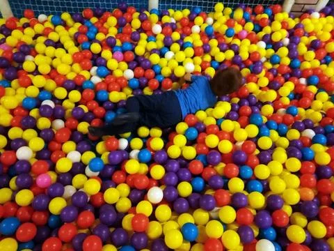 A boy is playing in the balls Фото