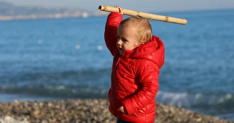 Boy Playing With A Bamboo Stick On The Beach Stock Footage 122257804