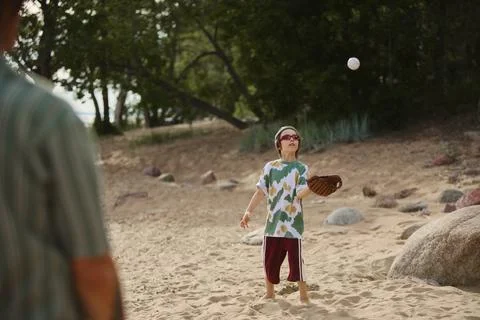 Boy Playing Baseball Catch with Father on Sandy Beach Stock Photos
