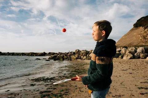 Boy playing bat and ball happily at the beach Stock Photos