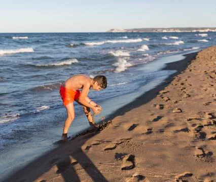Boy playing on the beach Stock Photos
