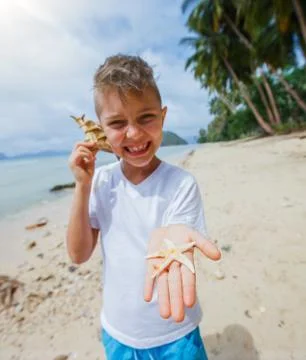 Boy playing at the beach. Fotos Stock