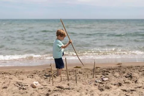 Boy playing at the beach Stock Photos