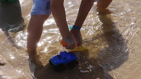 Boy playing with blue car in the beach Video stock 116725653