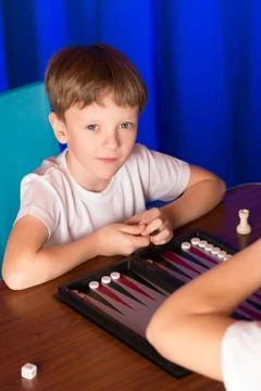 Boy playing a board game called Backgammon Stock Photos