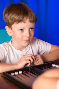 Boy playing a board game called Backgammon Stock Photos