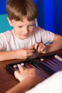 Boy playing a board game called Backgammon Stock-Fotos