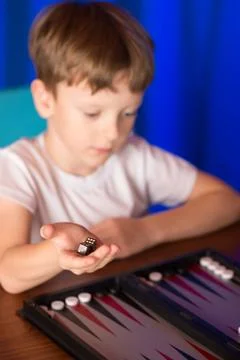 Boy playing a board game called Backgammon Stock Photos