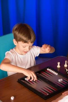 Boy playing a board game called Backgammon Stock Photos