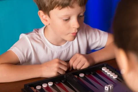 Boy playing a board game called Backgammon Stock Photos