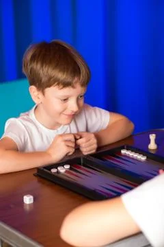 Boy playing a board game called Backgammon Stock Photos