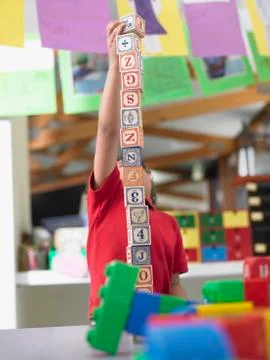 Boy Playing With Building Blocks In Class Foto stock