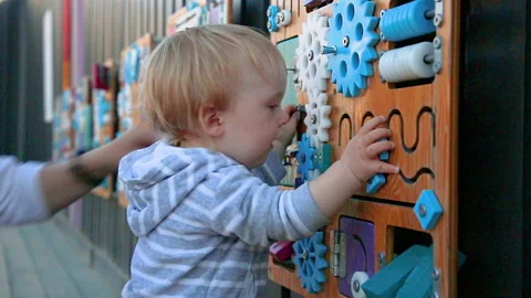 Boy is playing with busyboard Stock Footage 137577510