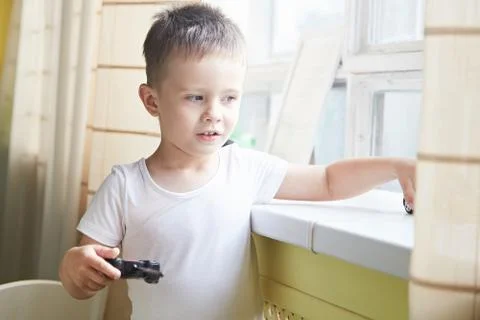 A boy playing with a car remote Stock Photos