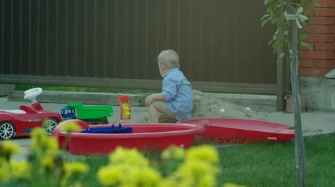 Boy Playing with Car in a Sandpit Stock Footage 56260013