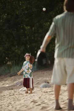 Boy Playing Catch with Father on Beach during Summer Vacation Stock Photos