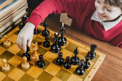 Boy playing chess with himself at home Stock-Fotos