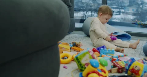 A boy is playing with colored blocks on a floor Stock Footage 150641805