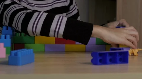 Boy playing in the colored blocks sitting at the table Stock Footage