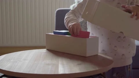 Boy playing with colored toy pieces in a white box 스톡 동영상 238992563