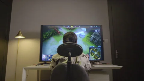 Boy playing computer games in front of big screen Stock Footage 240974650