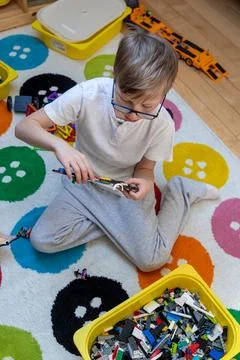 Boy playing with construction bricks on floor. Foto stock