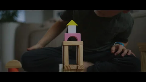 Boy playing with constructor wooden block building at home. Activities learning Stock Footage 269347486
