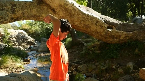 A boy playing in a creek in the woods Stock Footage 62896845