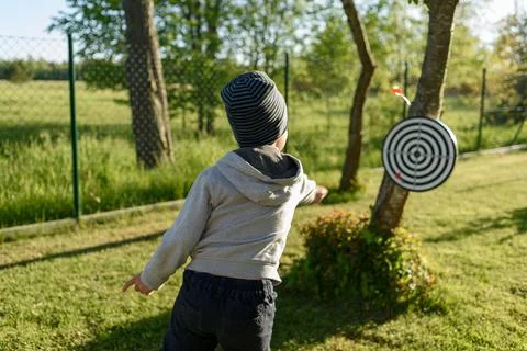 Boy playing darts at backyard Stock Photos