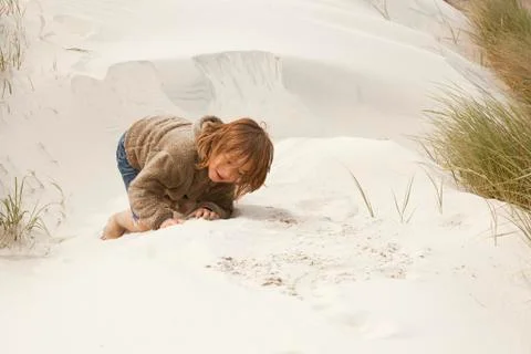 Boy playing in the dunes Stock Photos