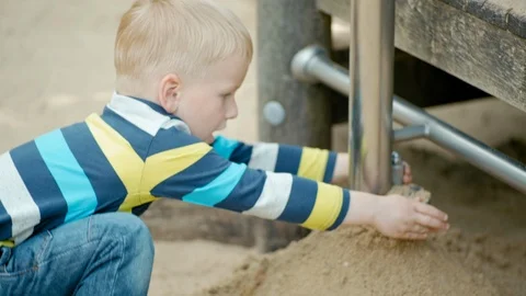 Boy is Playing with Educational Developing Equipment and Sand on the Playground 動画素材 104721148