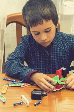 The boy playing an electric constructor. The child is played by intellectual Stock Photos