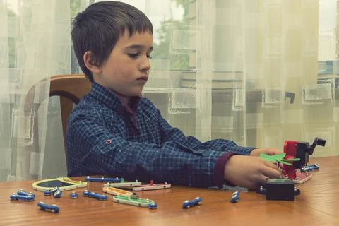 The boy playing an electric constructor. The child is played by intellectual Stock Photos