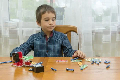 The boy playing an electric constructor. The child is played by intellectual Stock Photos