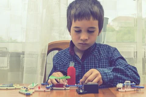 The boy playing an electric constructor. The child is played by intellectual Stock Photos