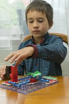 The boy playing an electric constructor. The child is played by intellectual Stock Photos